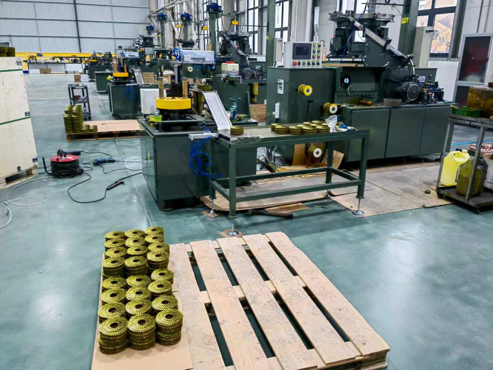 Finished coil nails — collated into tight uniform coils in yellow-coated finish